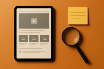 tablet sobre uma superfície laranja com bloco de notas e lupa