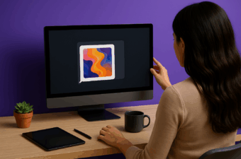 Mulher vista de costas trabalhando em um computador de mesa que exibe uma bolha de chat com arte abstrata gerada por IA; sobre a mesa de madeira estão um tablet, uma caneca de café e um pequeno vaso de suculenta, com fundo roxo.