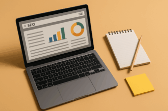 laptop com gráficos e bloco de notas ao lado