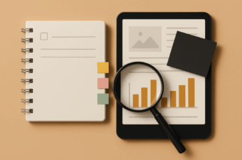 notebook, tablet, and magnifying glass on a brown background