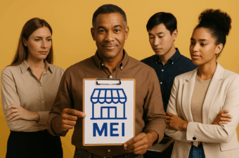 Grupo de pessoas segurando placa MEI em fundo amarelo.