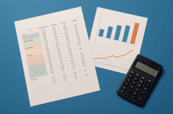 documentos com tabelas e gráfico ao lado de uma calculadora