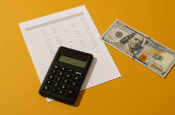 calculadora e notas de dinheiro sobre uma mesa