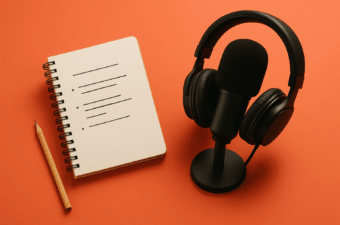 Microfone e caderno sobre mesa laranja