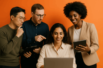 Quatro pessoas colaborando em um projeto com um laptop e dispositivos móveis.