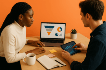 Duas pessoas em um escritório moderno com fundo laranja sólido discutem estratégias de marketing. Um notebook exibe um funil de conversão e gráficos sem texto, enquanto um tablet mostra barras e controles. Sobre a mesa, caderno aberto, caneta, post-its, caneca e pequena planta.