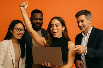 Grupo de pessoas felizes comemorando em frente a um laptop.
